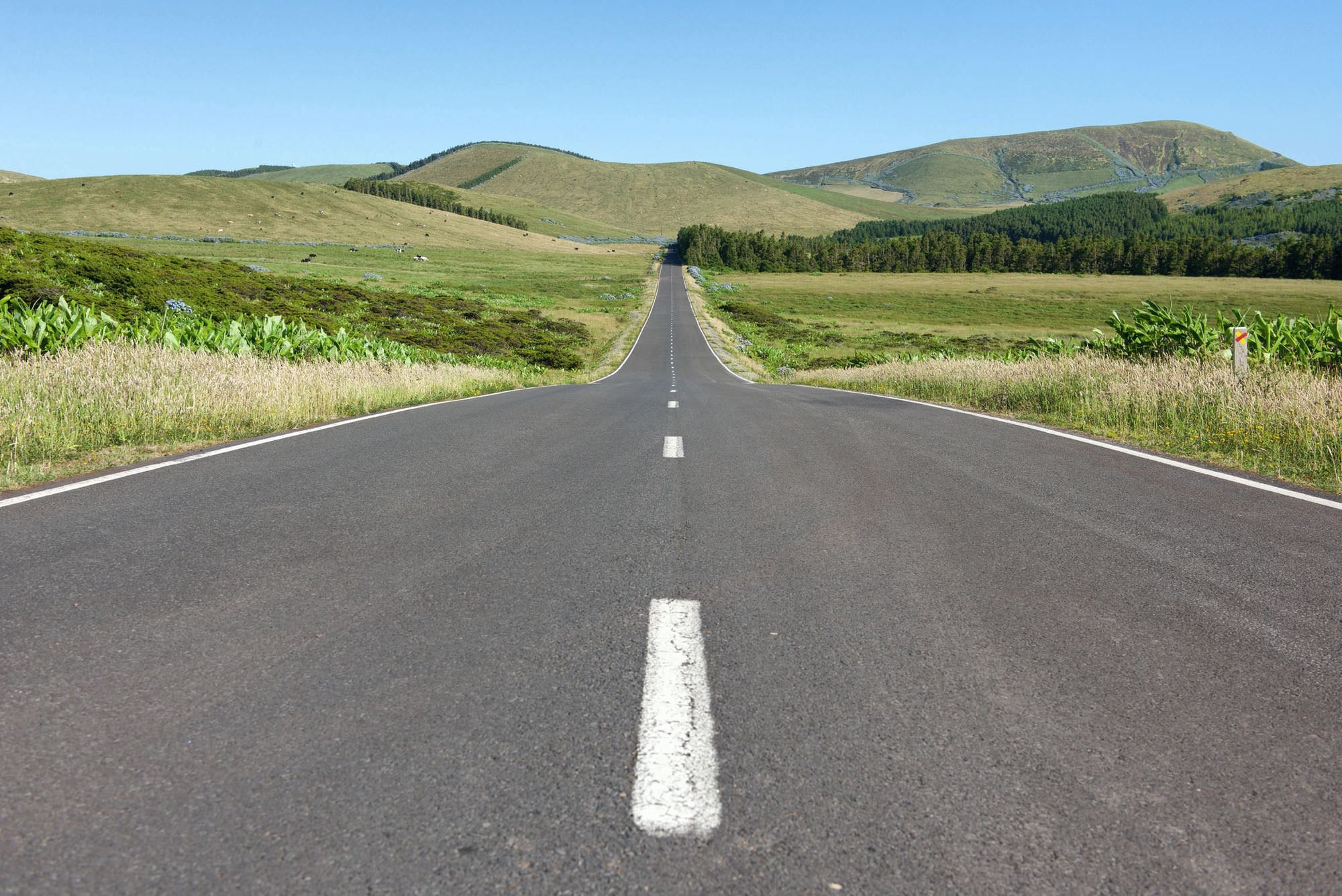 Eine einsame Straße durchschneidet das hügelige Hochland